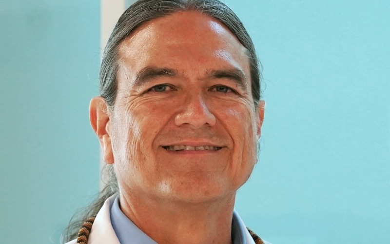 Dr. Donald Warne smiling in white physician's lab coat.