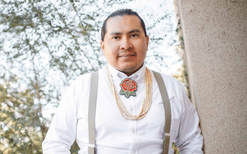 Joshua Allison-Burbank leaning against outdoor building wall.